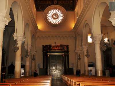 Voltandoci verso l�ingresso vediamo la luce del sole pomeridiano filtrare attraverso il rosone e illuminare le panche dei fedeli